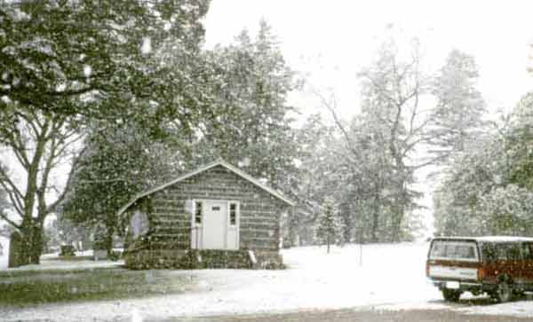 Photo of the log cabin in the winter.